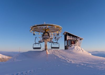 a ski lift sitting on top of a snow covered slope